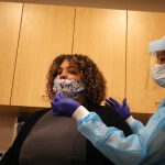 When should people who’ve already gotten COVID-19 get the vaccine? Doctors say it depends on whether they still have symptoms.